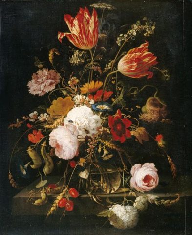 Flores en un jarrón de vidrio sobre un saliente de piedra